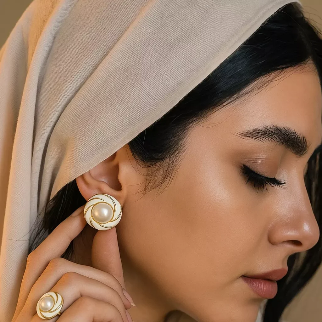 گوشواره زنانه میناکاری قرمز شرابی طرح پیچ با مروارید و رگه های طلایی در نمای نزدیک استایل ایرانی