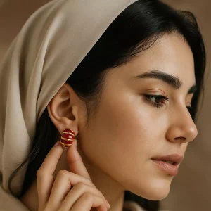 تصویر گوشواره میناکاری زنانه با طراحی خمیده و رنگ‌های قرمز و طلایی، اکسسوری شیک برای خانم‌ها